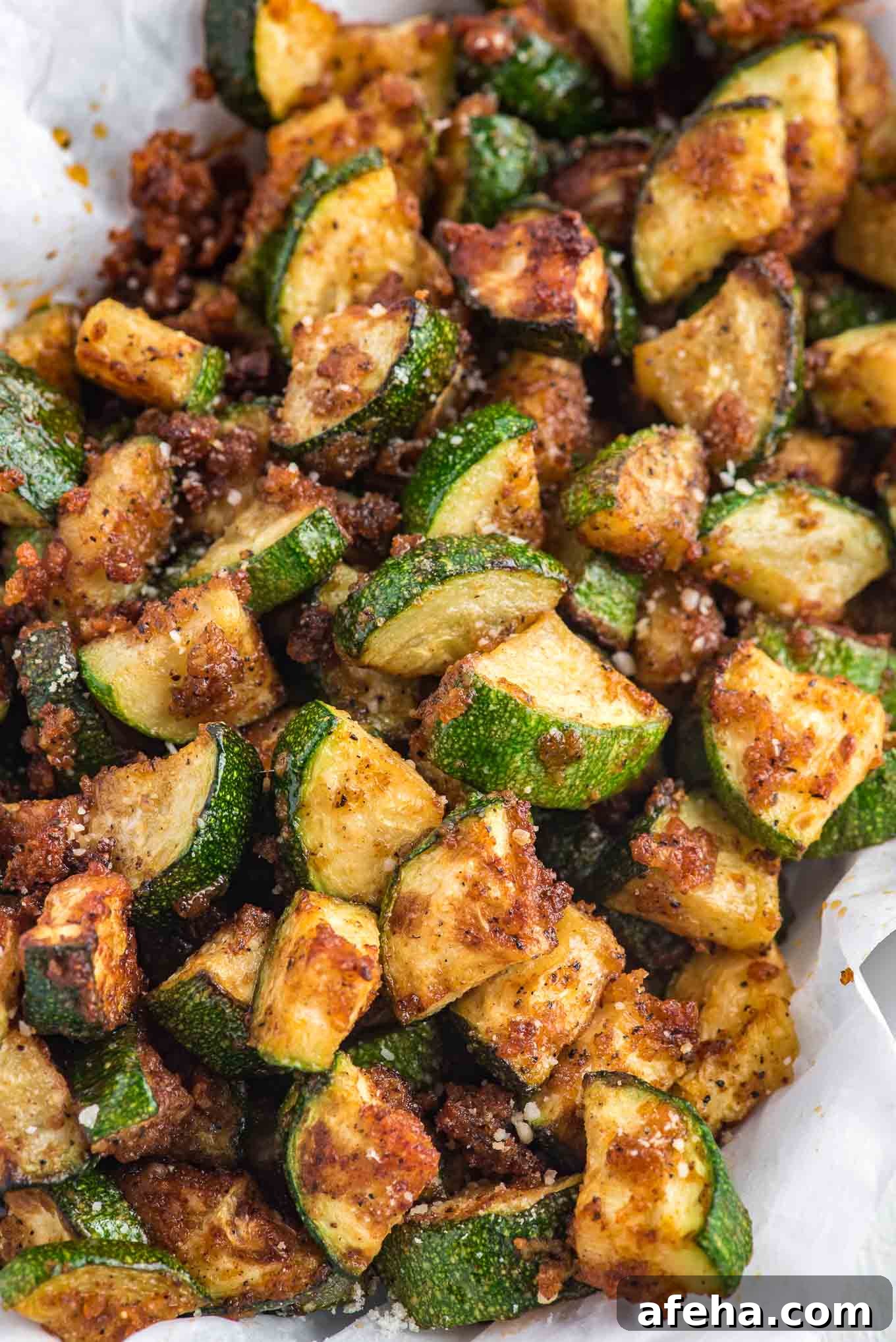 Zucchini in the air fryer on a plate with crispy edges.