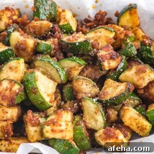 Air fryer zucchini with crispy coating on a white plate.