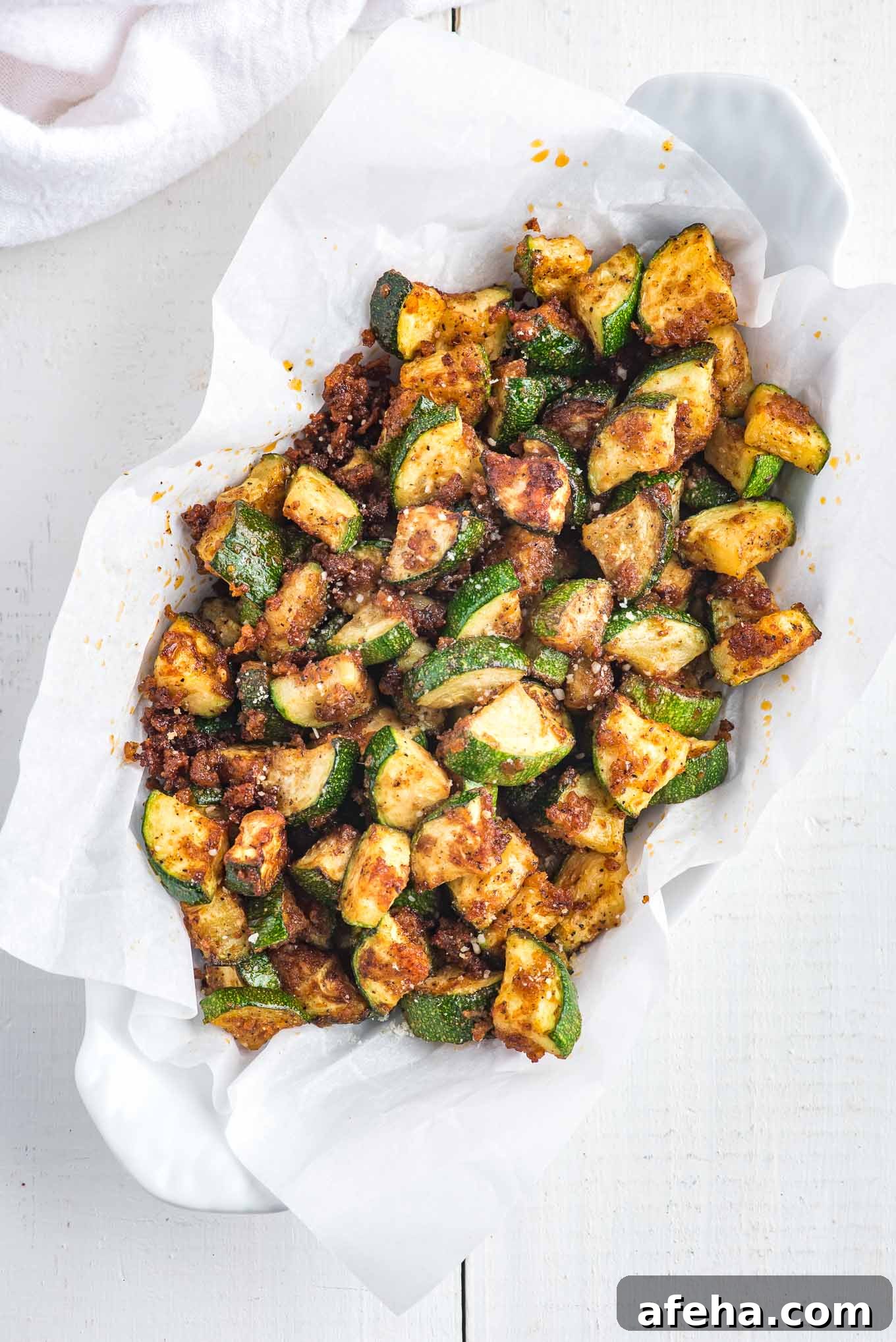 A paper lined oval dish filled with crispy zucchini.