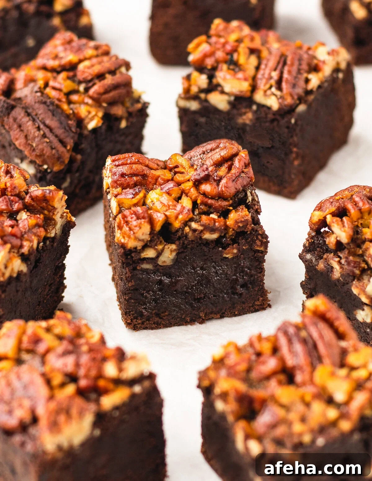 Homemade Pecan Pie Brownies Recipe — From Scratch and Rich 9 squares of Pecan Pie Brownies lined up on parchment paper