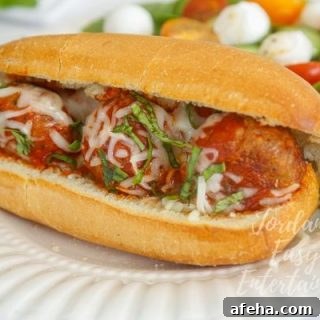 a meatball sub sandwich with a side salad