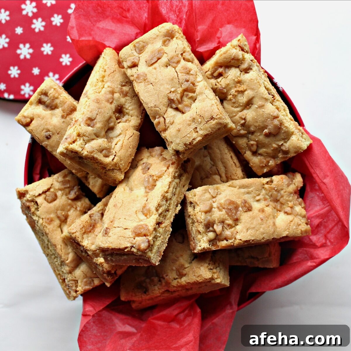 Butterscotch bars in a gift tin lined with red tissue paper.