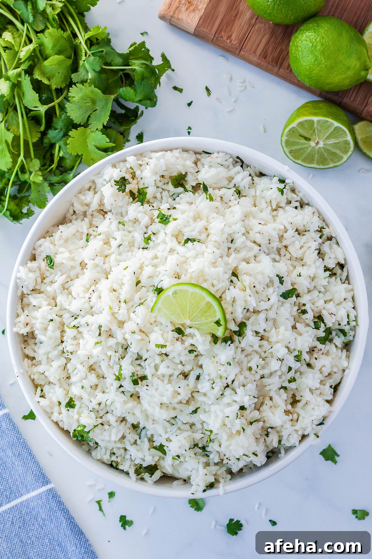 Cilantro lime rice in a white bowl and garnished with a lime wedge.
