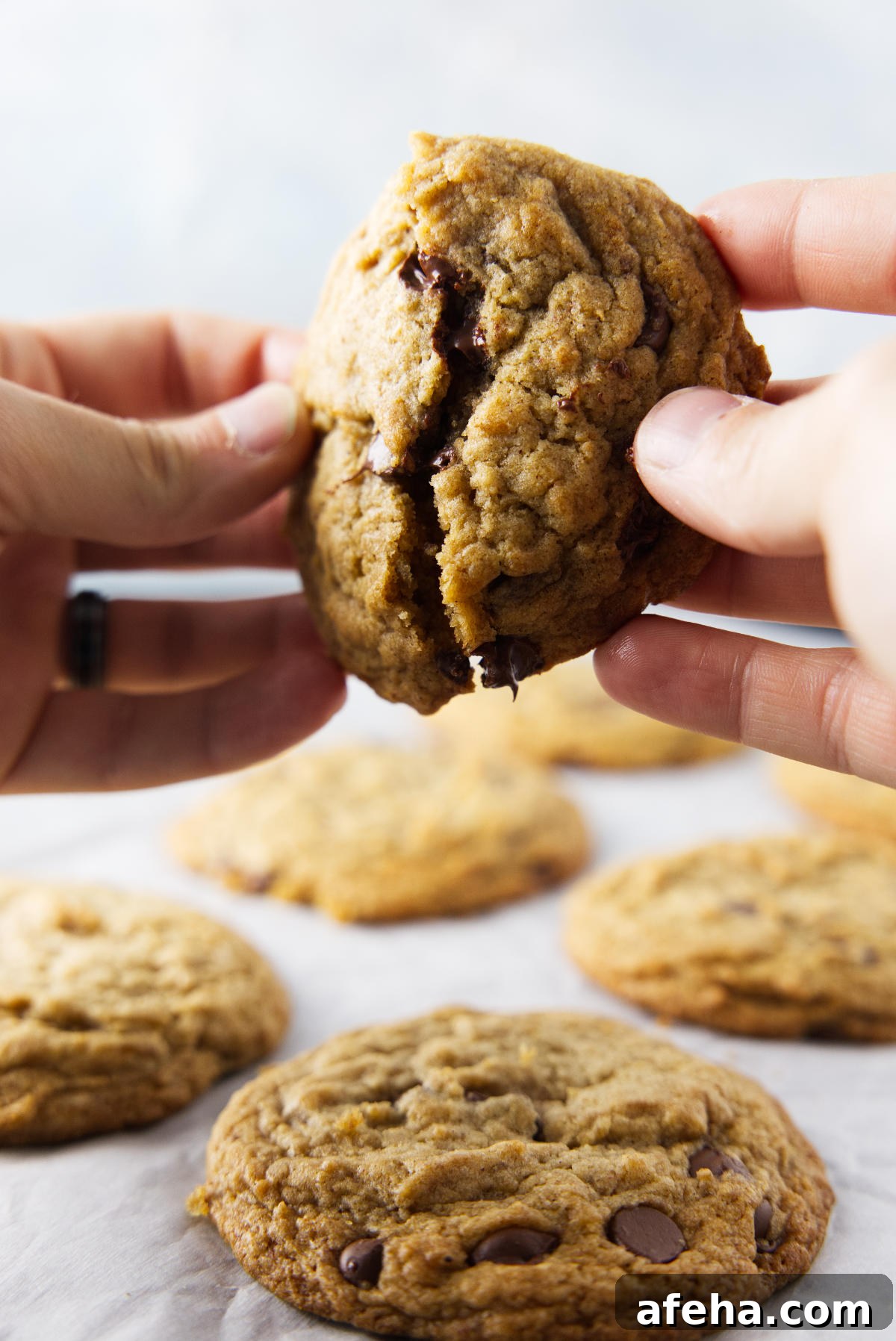 Breaking apart a banana bread chocolate chip cookie with a gooey center.