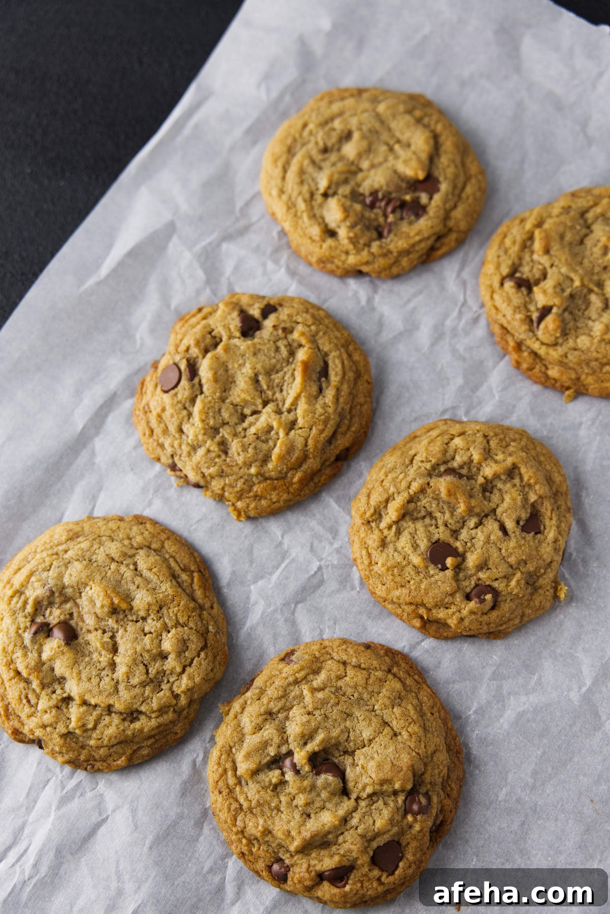 Several chocolate chip banana bread cookies on parchment paper.