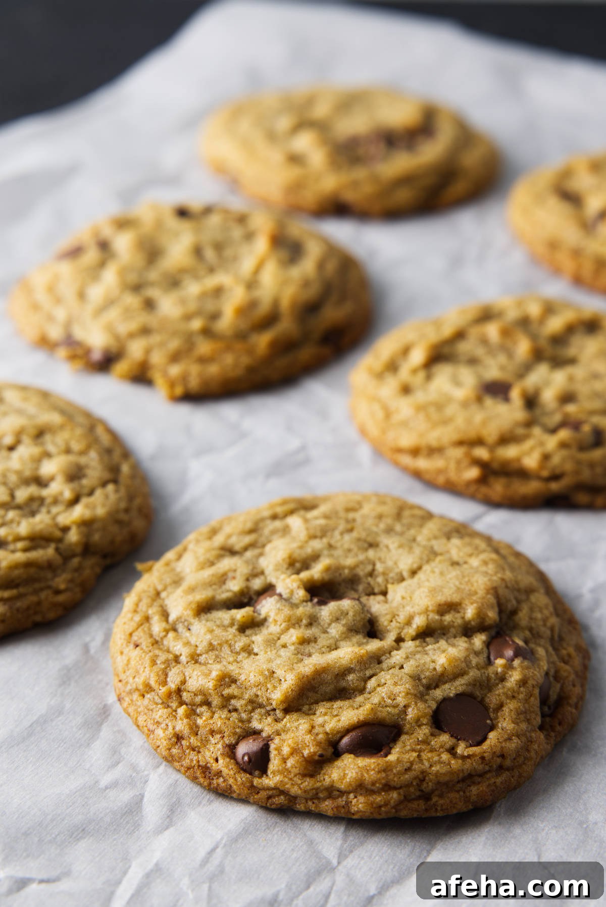Freshly baked banana bread cookies on parchment paper.
