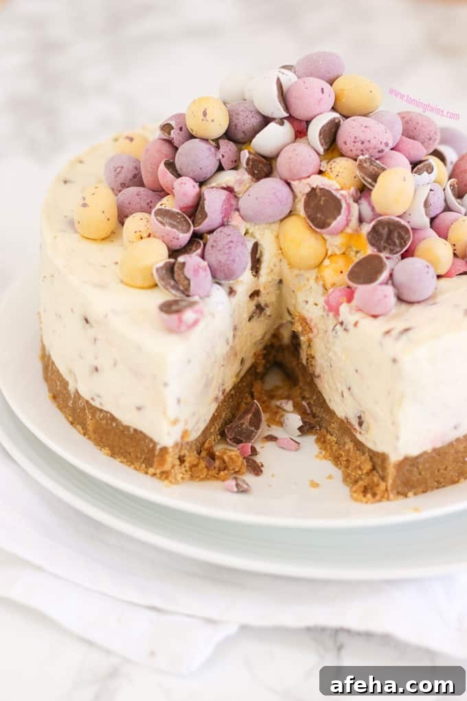 Mini Egg Cheesecake with a slice taken out on two white plates on top of a napkin.