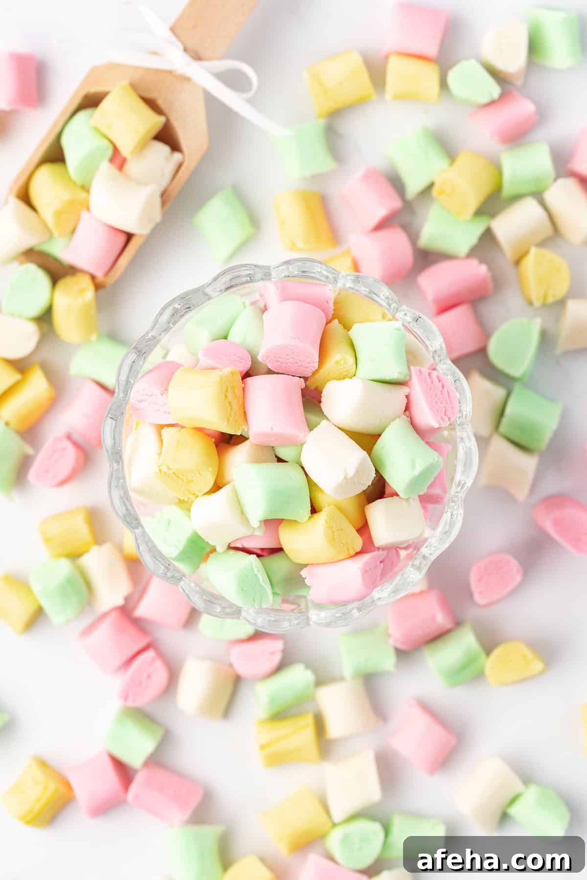 overhead view of a small glass dish full of butter mints with more mints scattered around