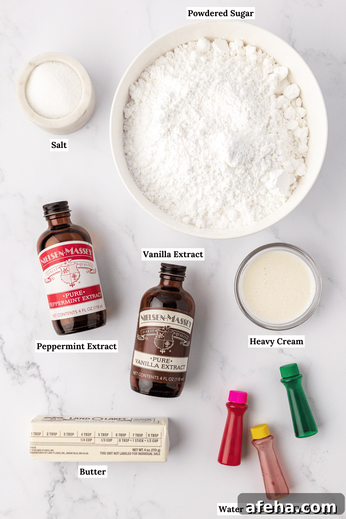 overhead view of ingredients for butter mints including powdered sugar, salt, peppermint extract, vanilla extract, heavy cream, butter and water based food coloring