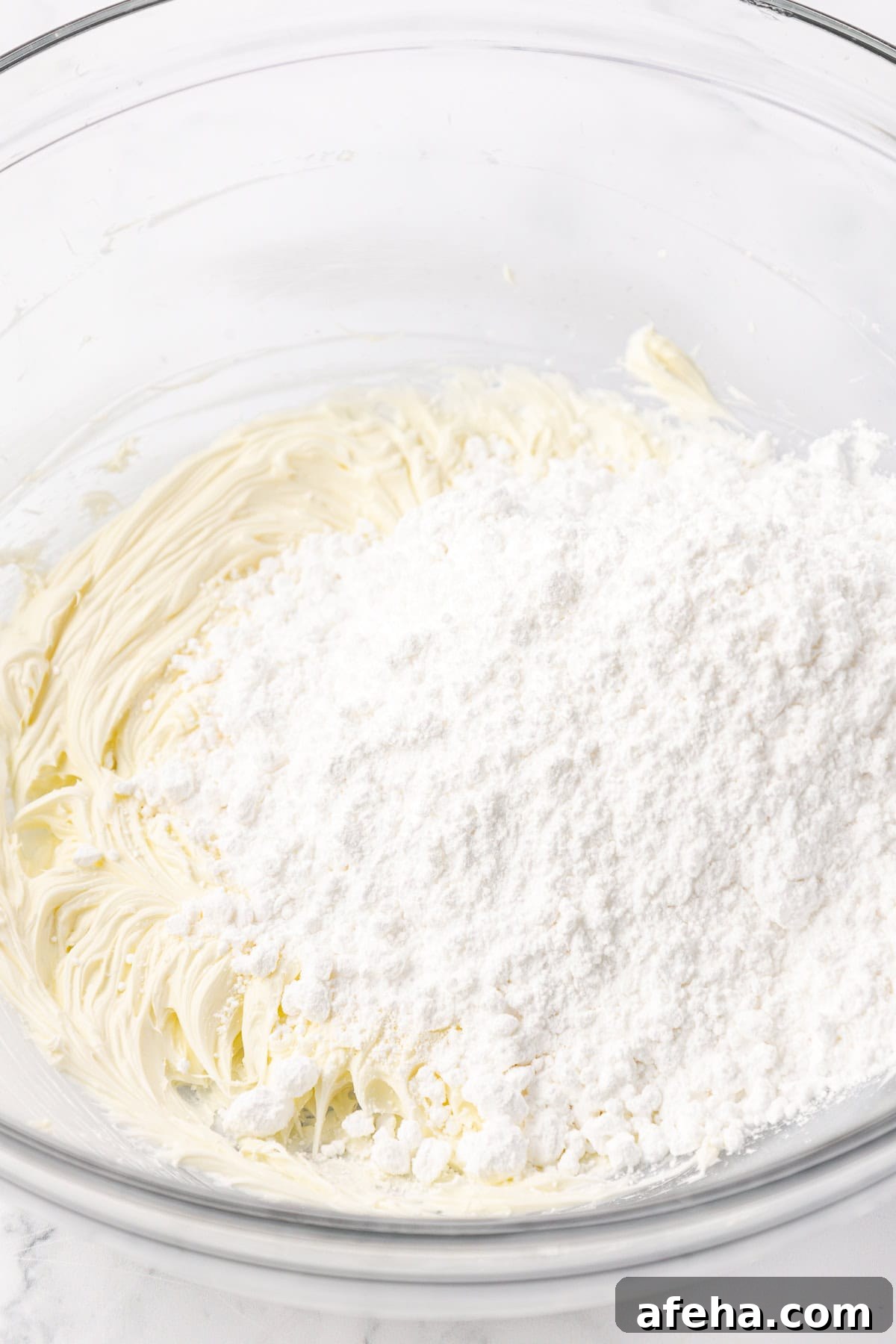 ingredients for butter mints in a clear glass bowl not yet combined