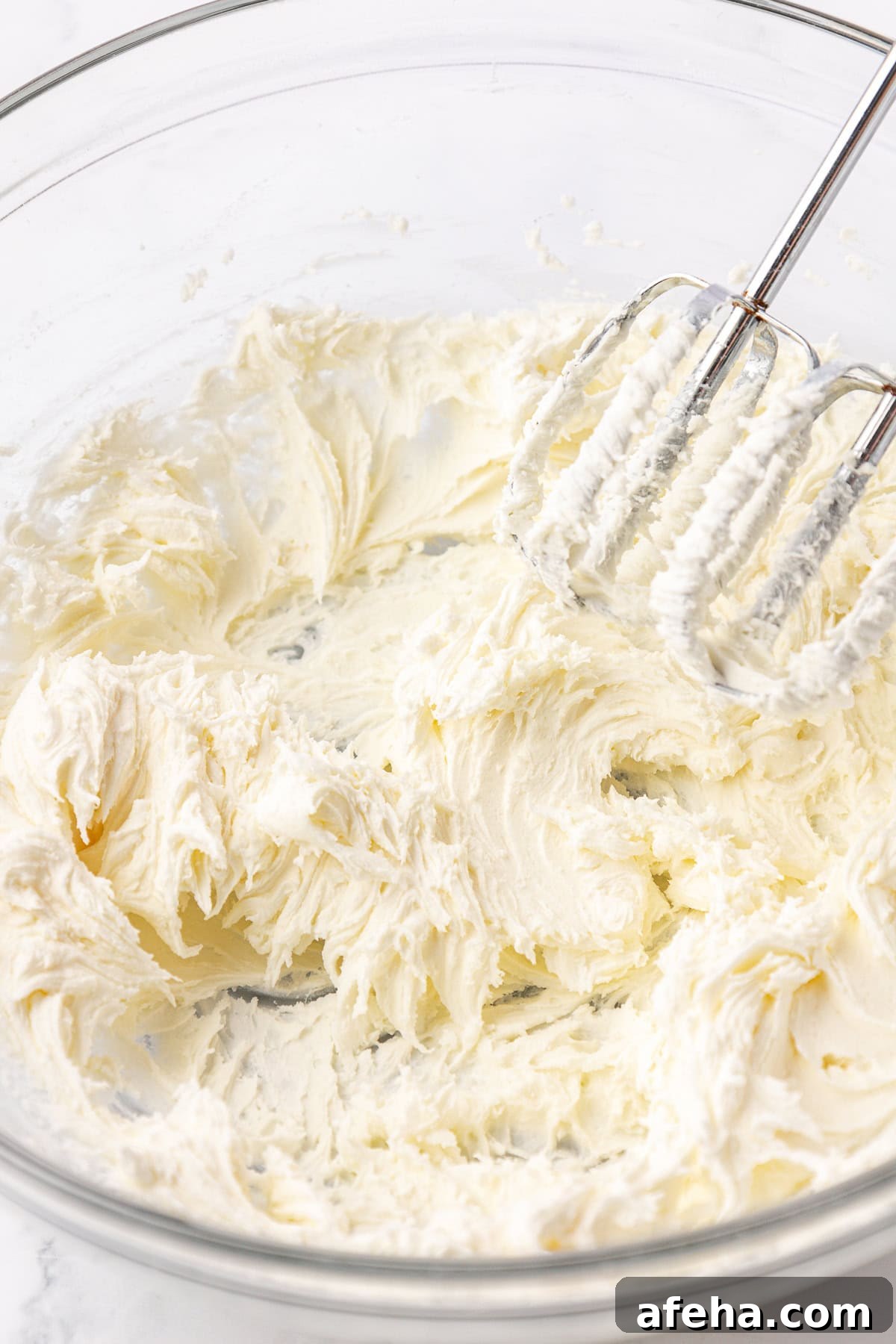ingredients for butter mints being mixed in a clear glass bowl