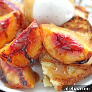 Close up of Grilled Pound Cake and Peaches on a white plate with a scoop of ice cream.