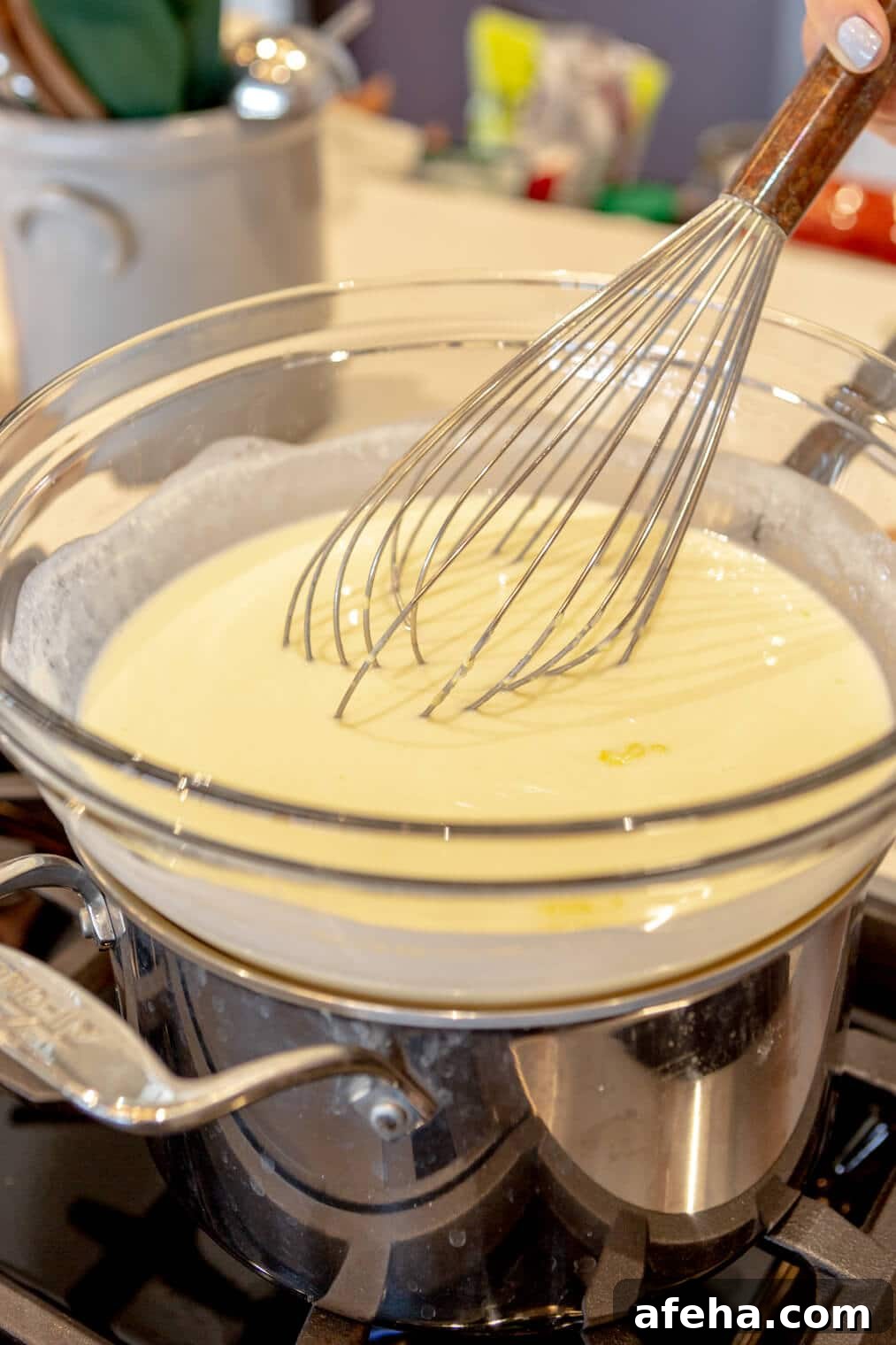 Wet ingredients whisked together in a large glass bowl over a double boiler.