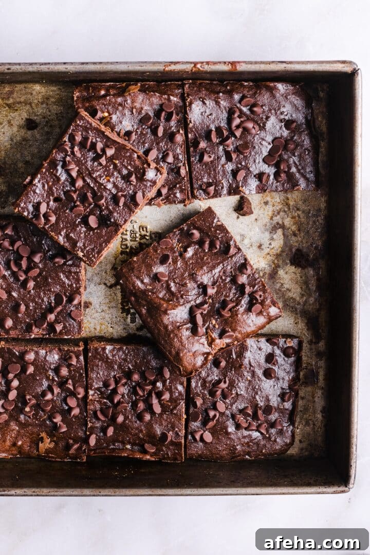 A tray of baked cottage cheese brownies, sliced into squares