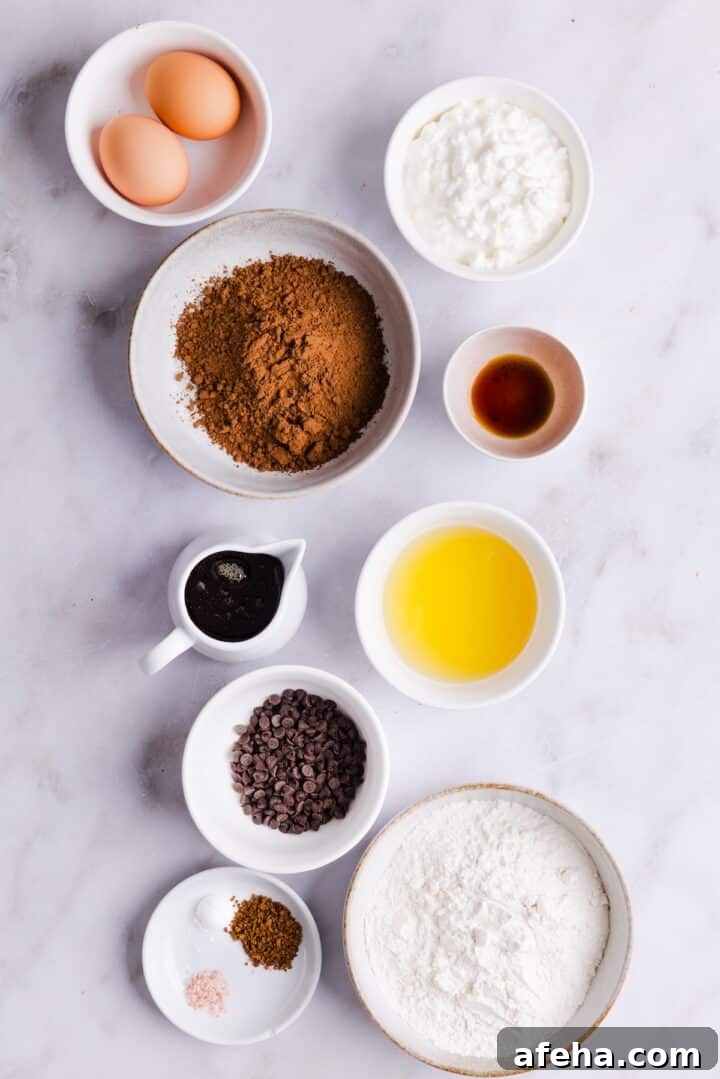 Ingredients for cottage cheese brownies displayed in small bowls on a white kitchen counter