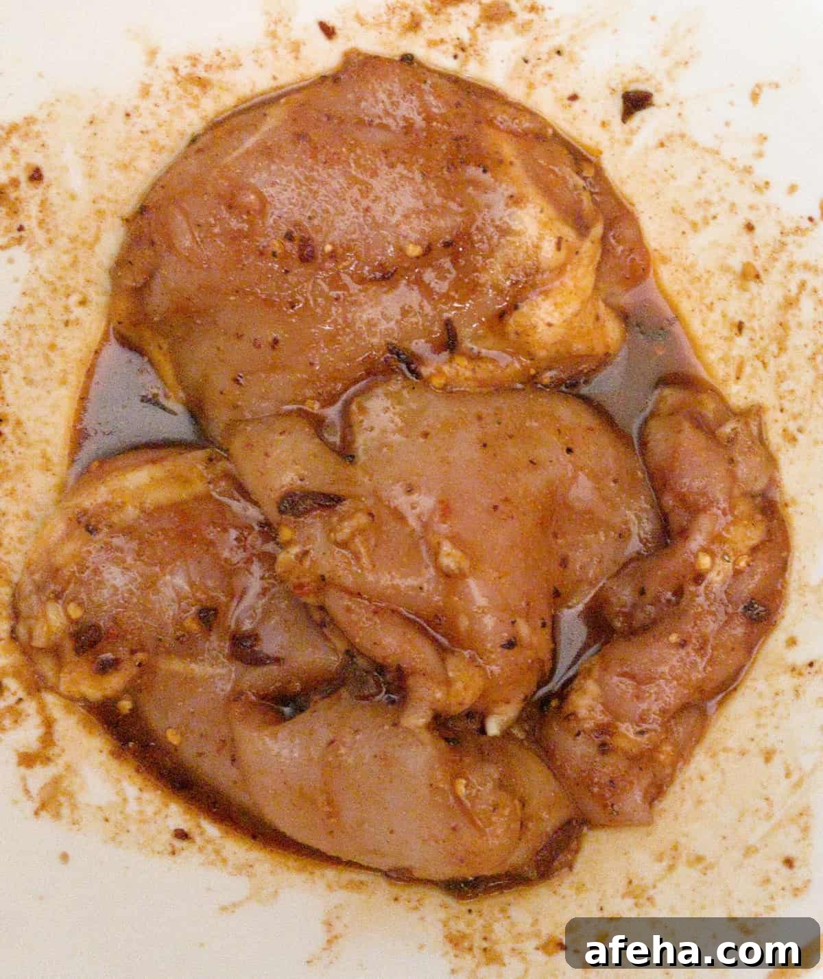 air fryer boneless chicken thighs in bowl with spices and marinade