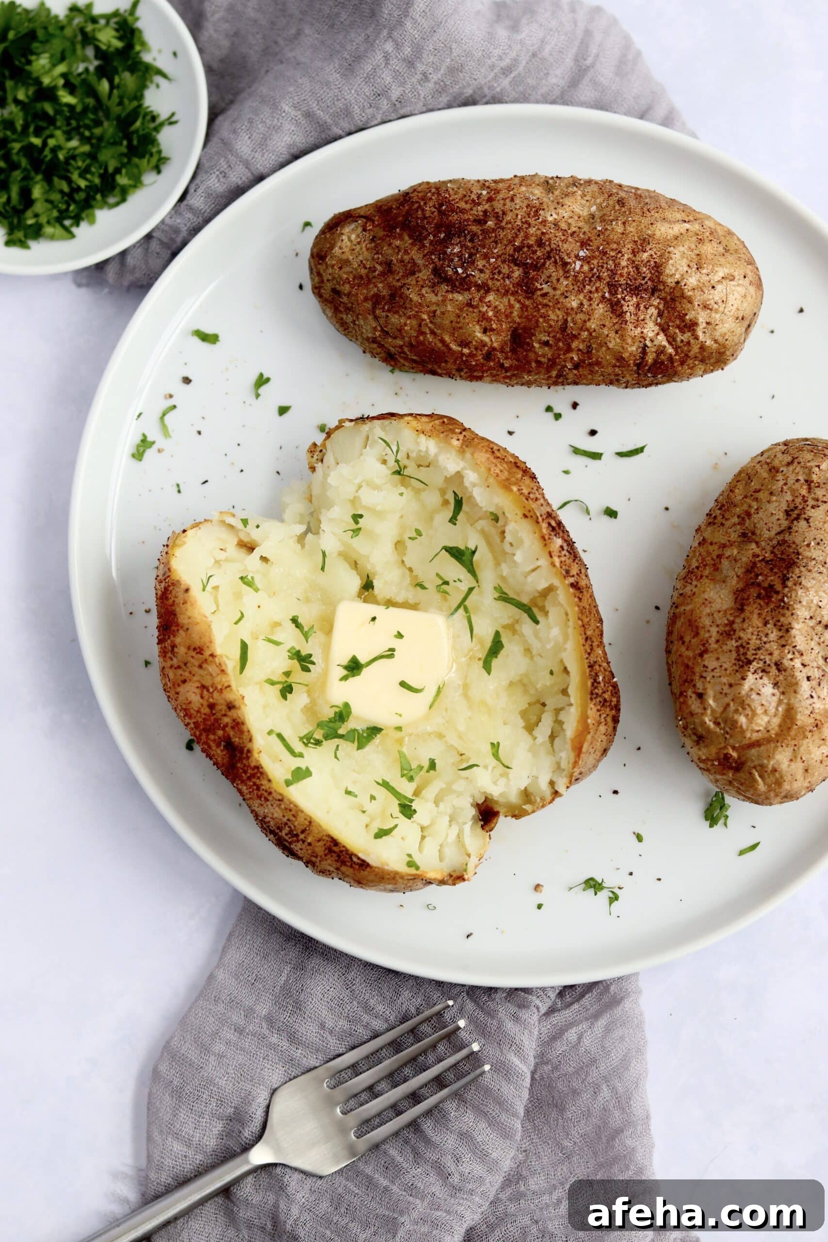 Baked potatoes on a plate with butter