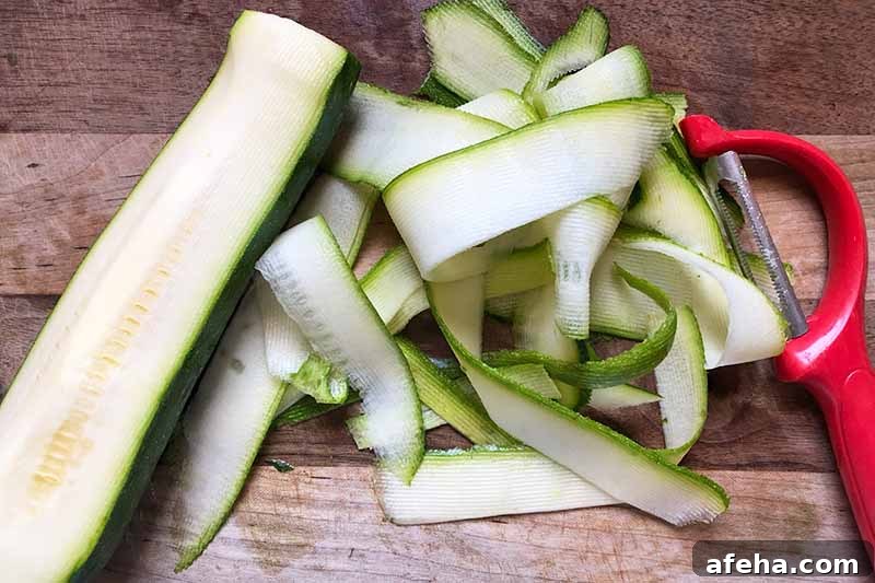 Horizontal image of peeling squash with a vegetable peeler on a wooden cutting board.