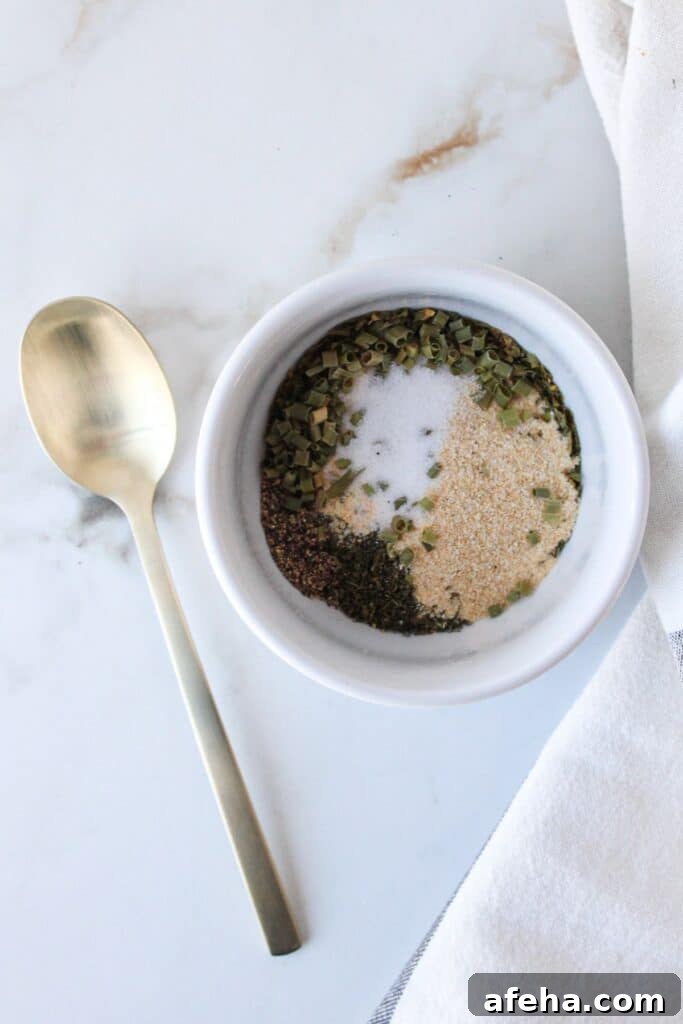 A mixture of spices in a small white bowl with a gold spoon.