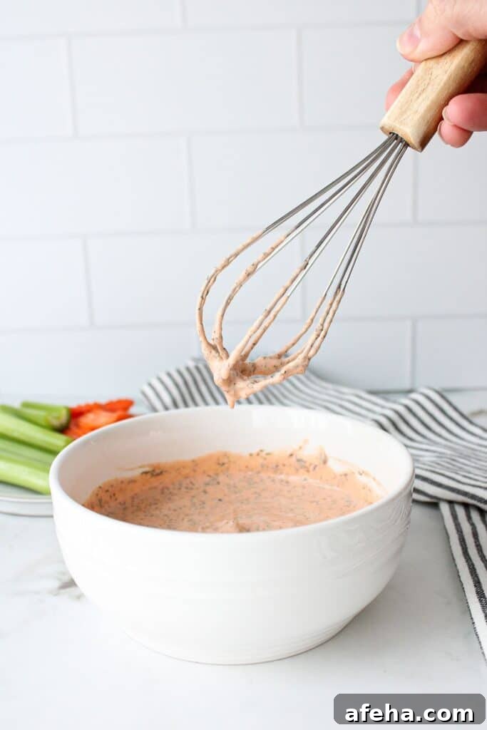Bowl of buffalo ranch sauce with a whisk.