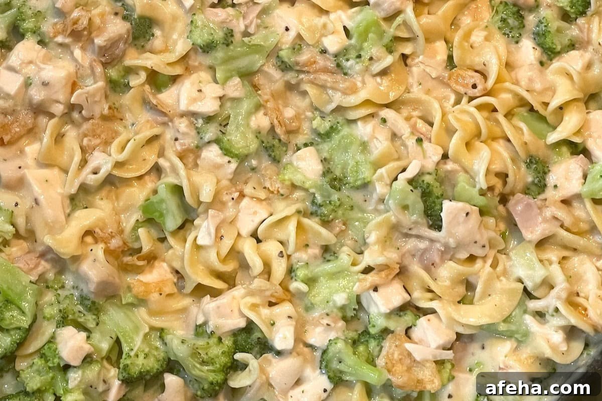 Cheesy chicken and broccoli noodle casserole in a baking dish.