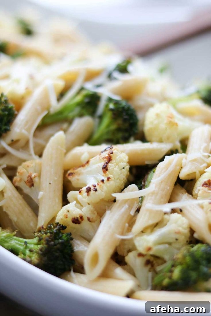 Closeup of pasta heaped in white serving bowl.