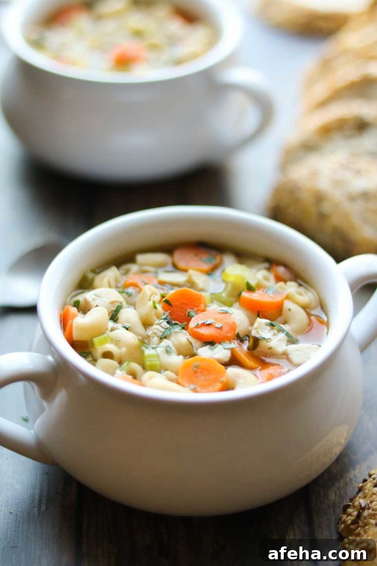 Bowl of Rotisserie Chicken Noodle Soup with bread.