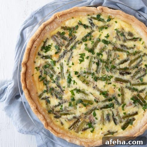 asparagus quiche sitting on a blue tea towel.
