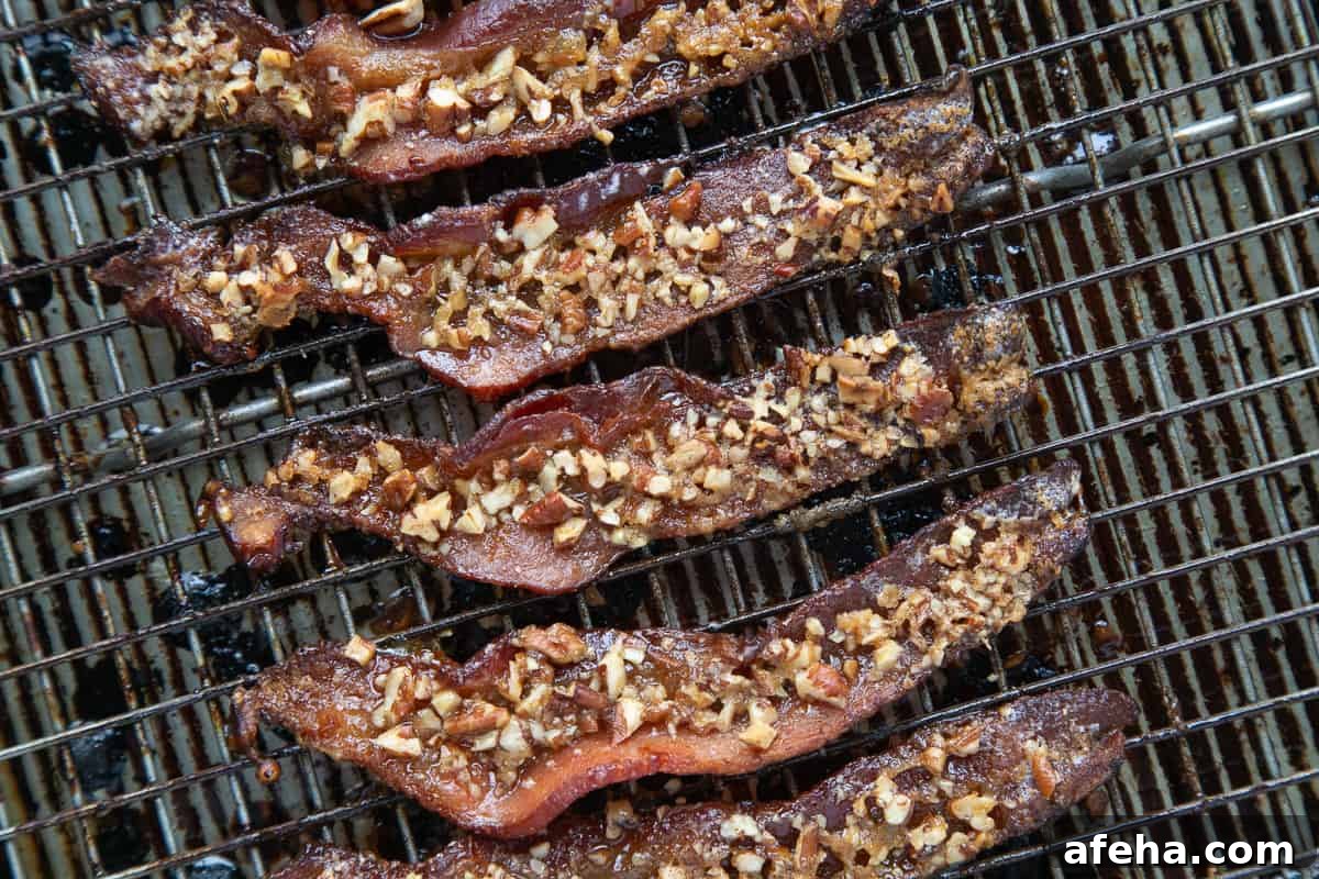 Praline-Crusted Candied Bacon — Sweet & Crunchy Bacon Recipe 7 cooked praline candied bacon on a wire rack.