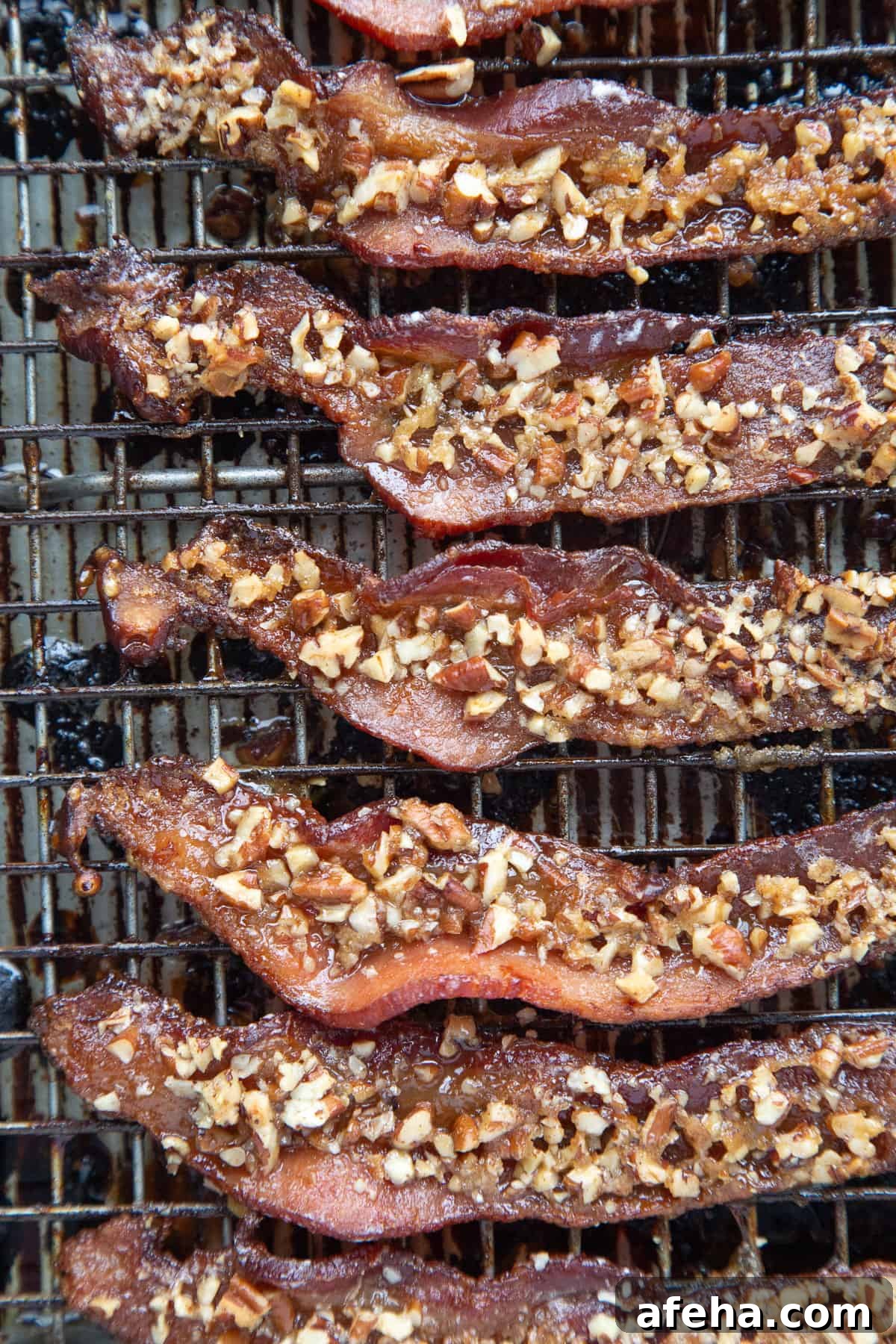 Praline-Crusted Candied Bacon — Sweet & Crunchy Bacon Recipe 8 praline bacon lined up on a wire rack.