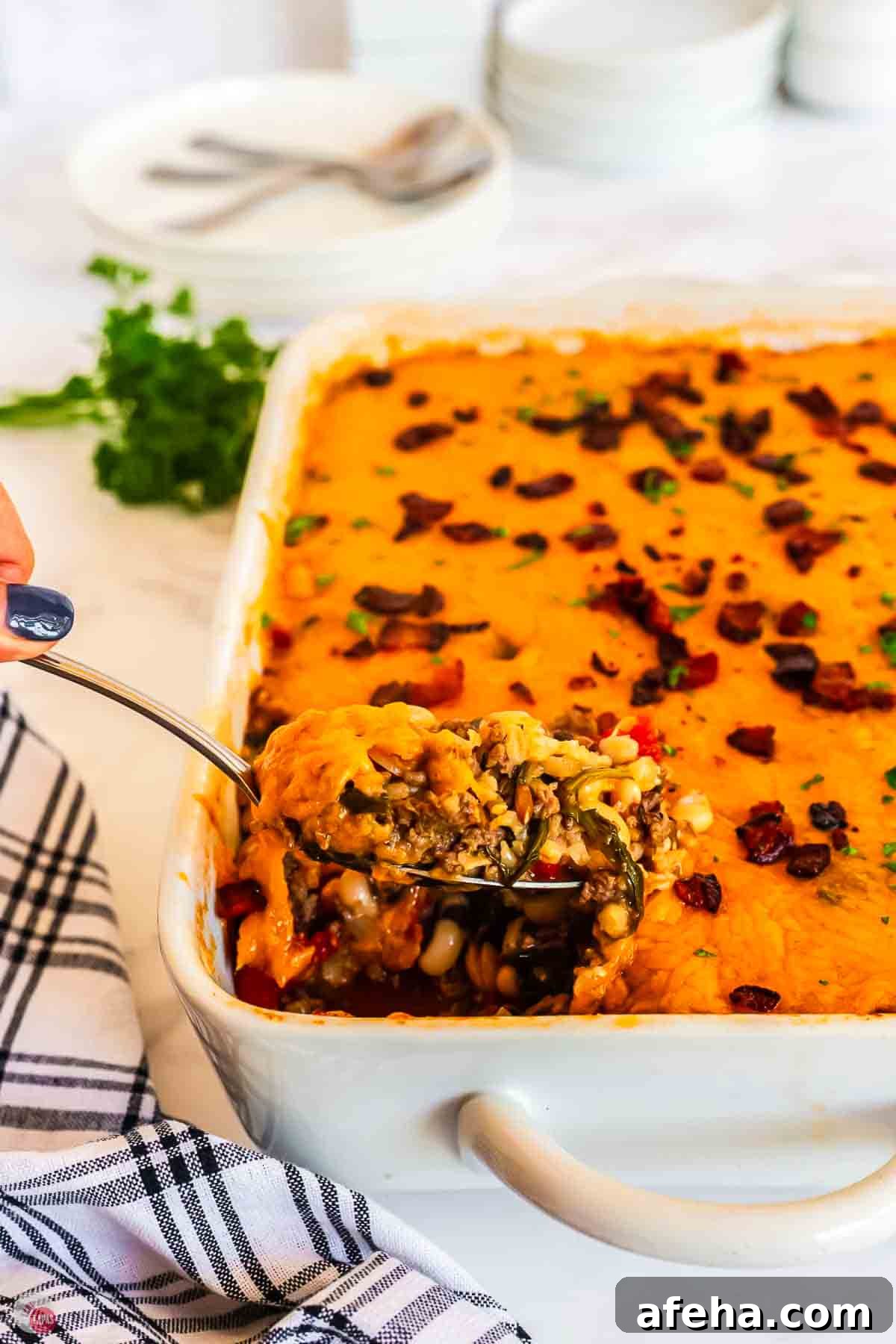 spoon scooping out casserole from a white dish