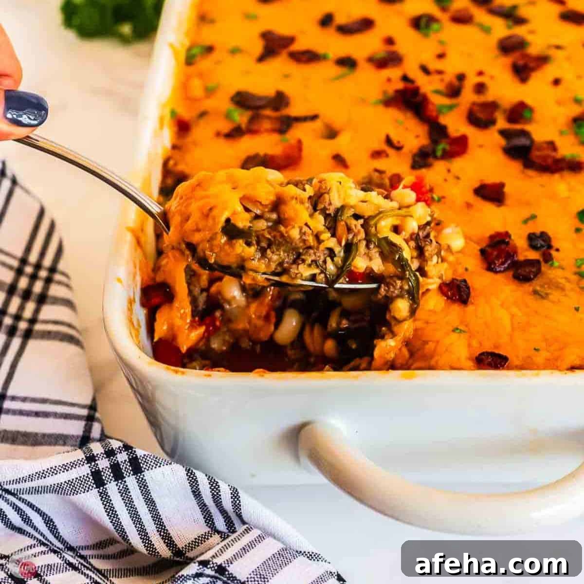 spoon with scoop of black eyed pea casserole and a blue and white napkin