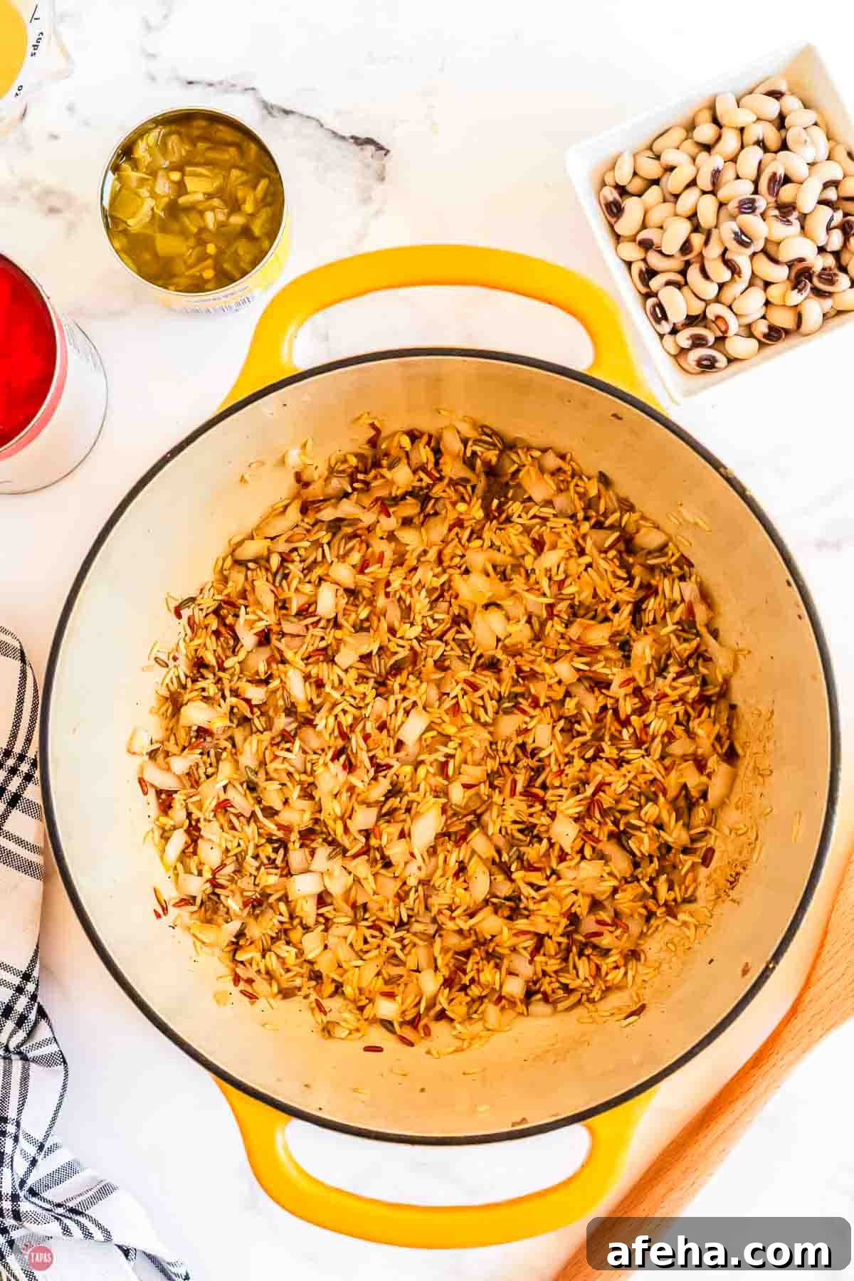 toasted rice and onion in a yellow pot