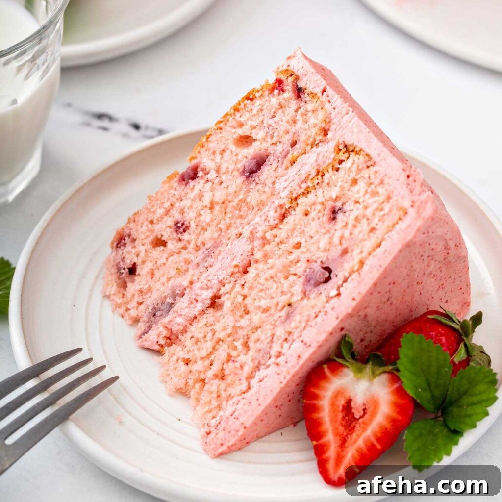 A slice of fresh strawberry cake with buttercream