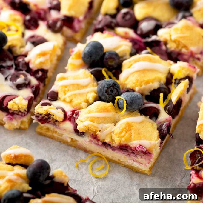 Lemon Blueberry crumb bars cut into squares on a piece of parchment paper