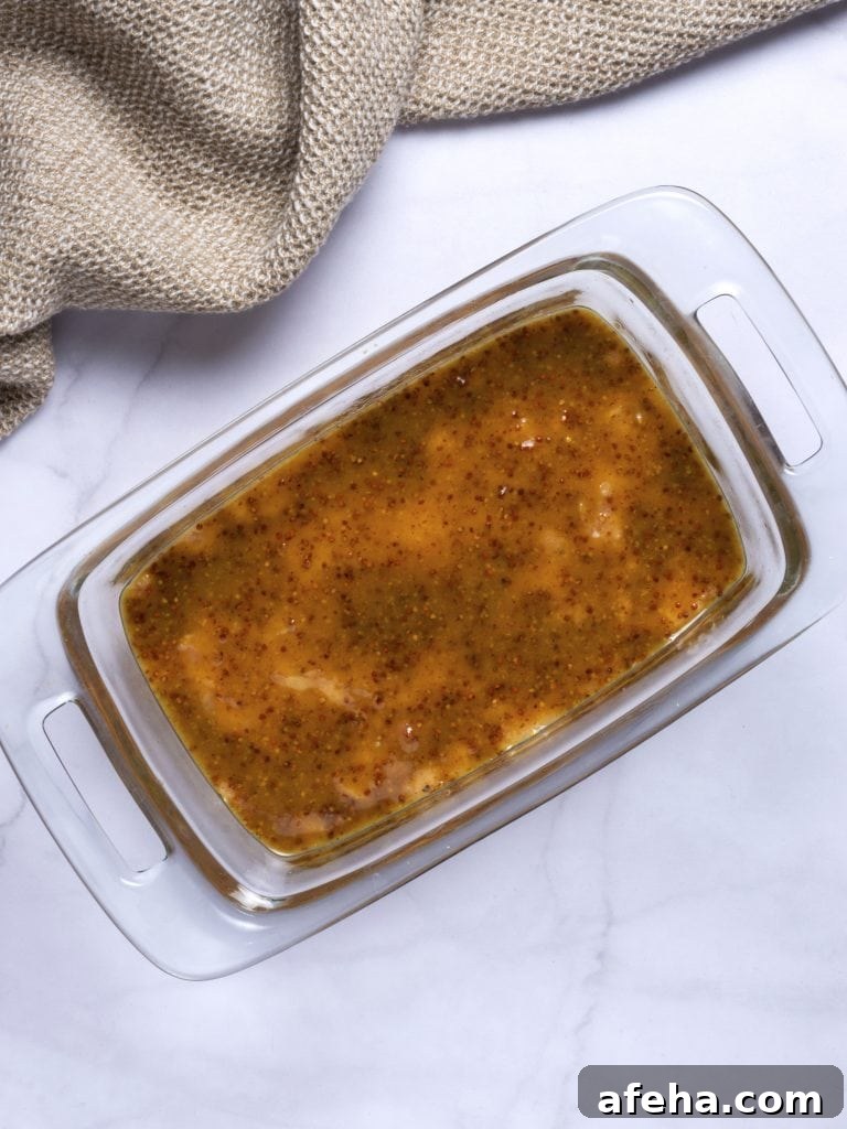 chicken meatloaf with honey mustard glaze in a glass loaf pan before baking