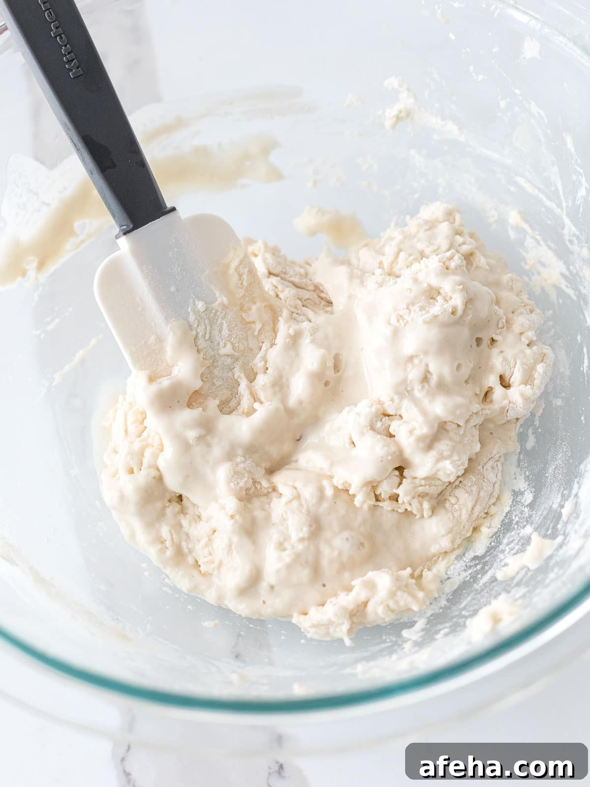water and flour mixture combined with a spatula in a glass bowl