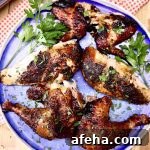 grilled chicken pieces on a blue plate with parsley garnish
