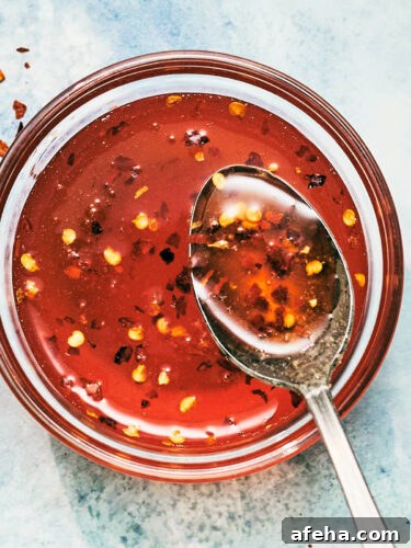 Easy homemade Hot Honey Sauce in a bowl with a spoon.