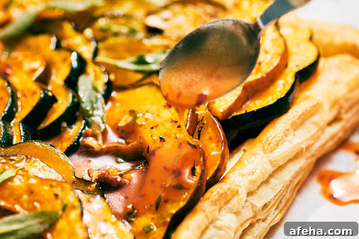 Honey hot sauce being drizzled over a Roasted Squash and Sage Tart.