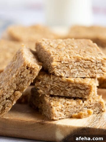 A stack of no bake peanut butter flapjacks on a wooden board.