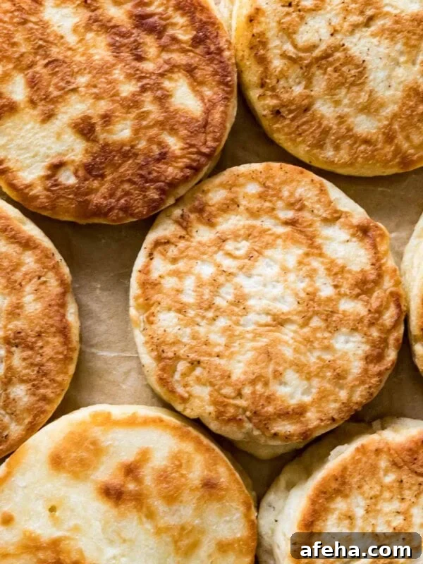 Overhead view of golden brown sourdough English muffins.