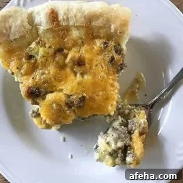 Sausage cheddar quiche slice on a fork.