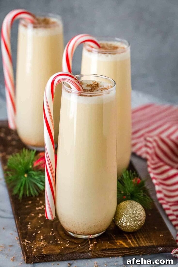 A chocolate peppermint eggnog cocktail garnished with a candy cane.