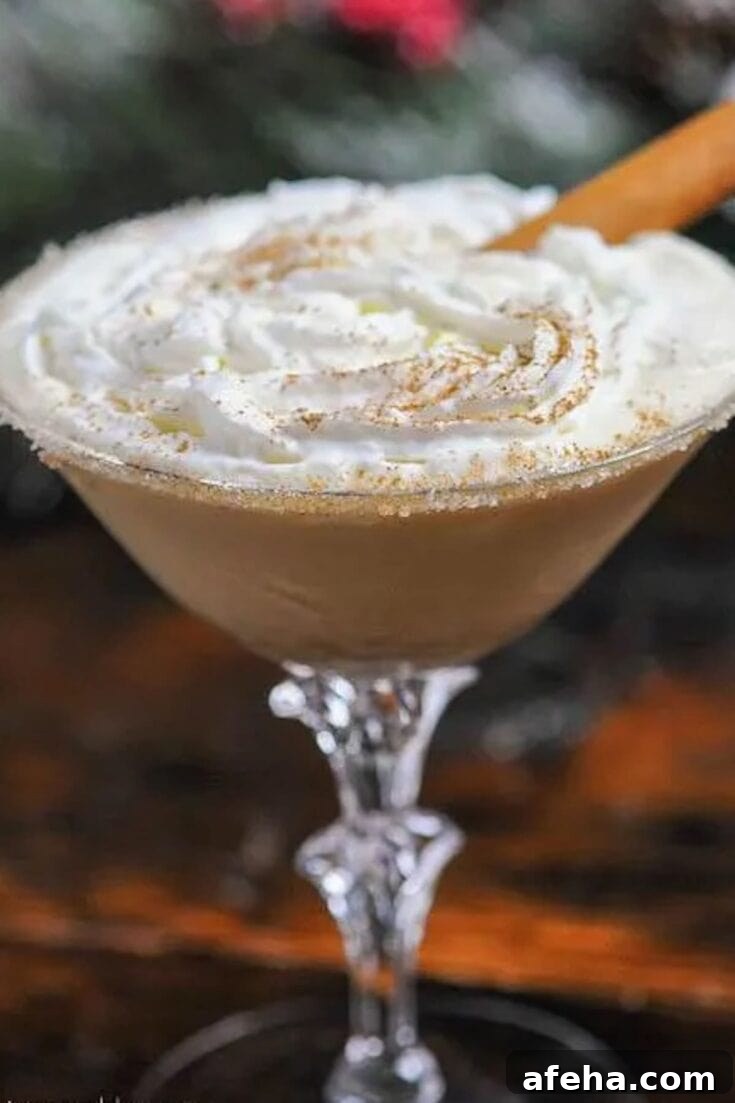 A gingerbread eggnog cocktail garnished with whipped cream and a cinnamon stick.