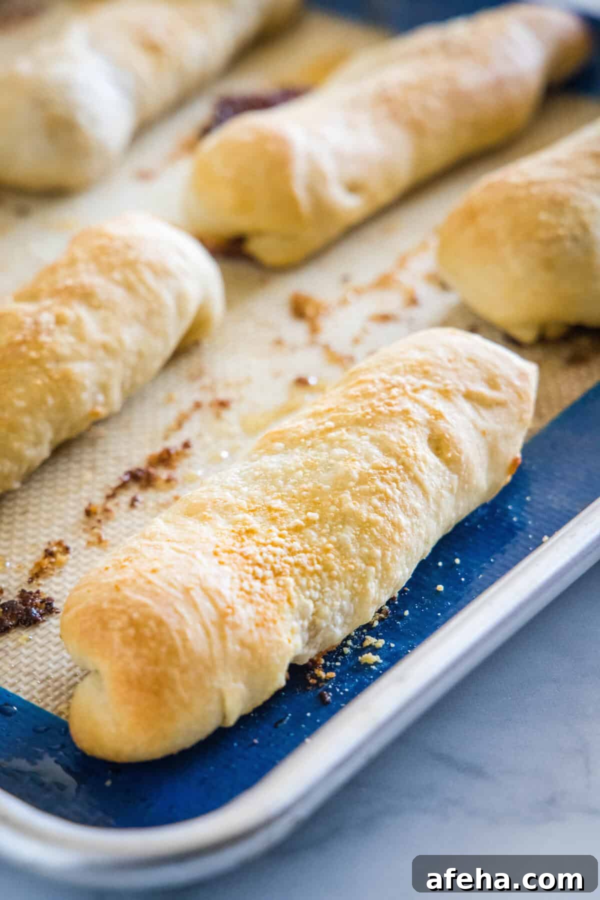 Baked pepperoni rolls on a lined baking sheet.