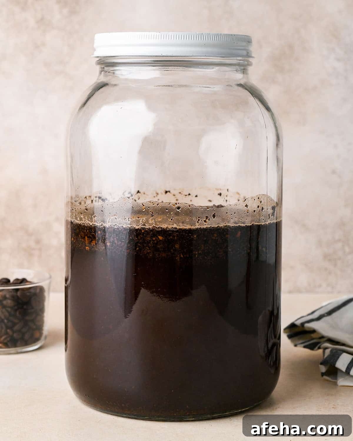 cold brew coffee steeping in a glass jar with a white lid