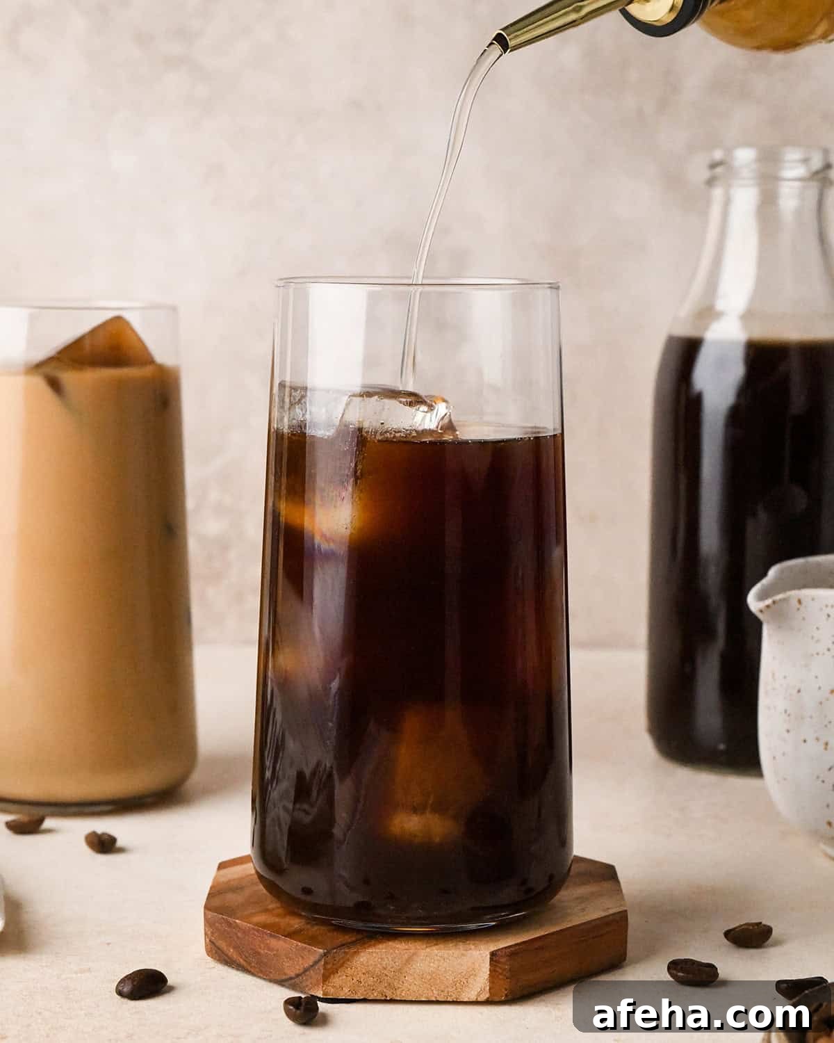 simple syrup being poured into a glass of Cold Brew Coffee