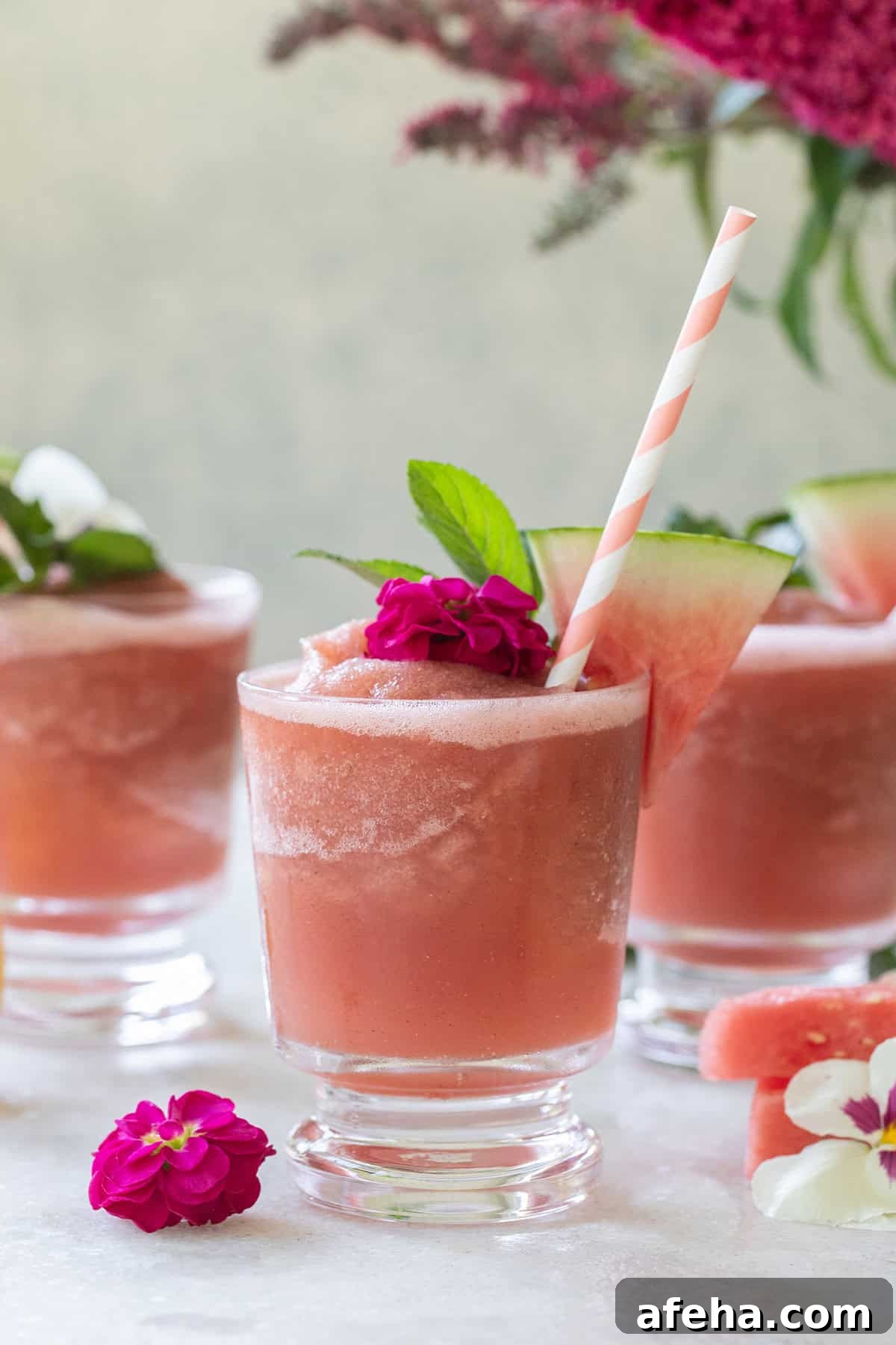 Watermelon Frosé Recipe: Refreshing Summer Rosé Slush 3 Easy watermelon frose with straws and flowers on a tray to serve for a summer gathering.