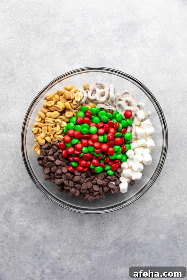 Christmas Trail Mix: Sweet and Salty Holiday Snack Recipe 5 Peanuts, chocolate chips, pretzels, marshmallows, and M&Ms in a bowl.